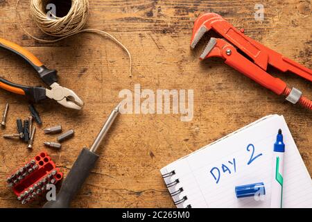 Screwdriver, notebook, screws and other tools on a wooden surface Stock Photo