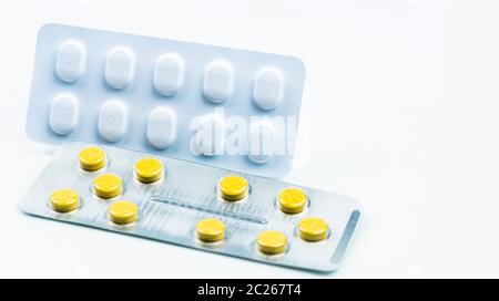 Ergotamine drug interactions concept. Yellow tablet pills and white blister pack. Migraine headache treatment with pills. Pharmaceutical industry. Bac Stock Photo