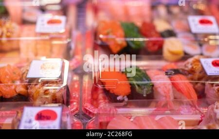 Selective focus on sushi set in plastic box display in shelf at supermarket. Japanese food for take away. Sushi delivery business. Healthy food ready Stock Photo