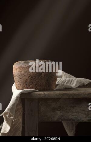 baked rye bread on a gray linen napkin, old wooden table, copy space Stock Photo