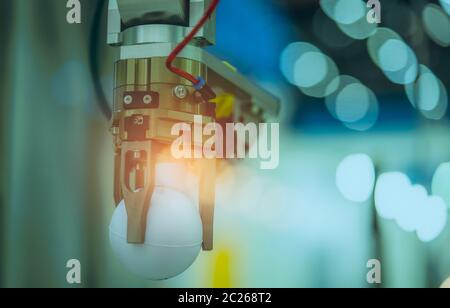 Closeup robot hand machine picking up white ball on bokeh blurred background . Use smart robot in manufacturing industry for industry 4.0 and technolo Stock Photo