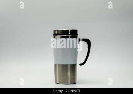 Stainless steel modern thermos bottle isolated on white background. Coffee, tea, and warm water bottle. Thermos bottle and brown lid with blank label. Stock Photo