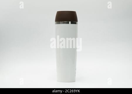 Modern thermos bottle isolated on white background. Coffee, tea, and warm water bottle. White thermos bottle and brown lid with blank label. Insulated Stock Photo