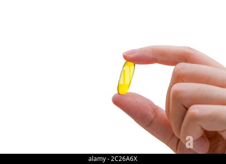 Young woman hand hold fish oil capsule. Woman taking omega-3 pills. Vitamins and supplements concept. Stock Photo