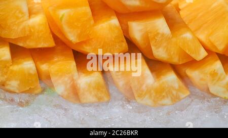 Orange or yellow pineapple sliced on crushed ice. Tropical fruit. Healthy snack. Bromelain enzyme extracted from pineapple. Source of nature enzyme he Stock Photo