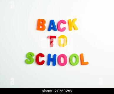 inscription back to school from multi-colored plastic letters on a white background Stock Photo