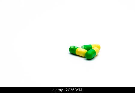 Green, yellow tramadol capsule pills on white background with shadows and copy space. Cancer pain management. Opioid analgesics. Drug abuse in teenage Stock Photo