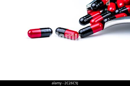 Red and black capsule pills on stainless steel drug tray. Antibiotics drug resistance. Global healthcare. Antimicrobial capsule pills. Pharmacy backgr Stock Photo