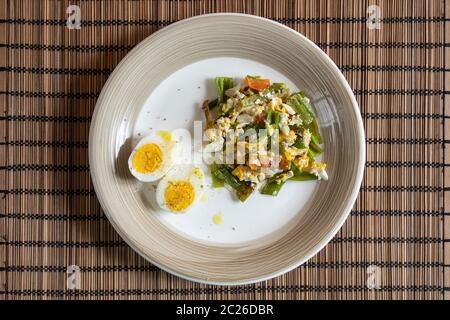 a dish with boiled eggs and scrambled eggs with green peppers Stock Photo