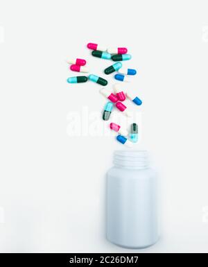 Pouring antibiotics capsule pills into plastic bottle isolated on white background with copy space. Drug storage, antibiotic drug use with reasonable, Stock Photo