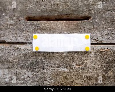 mailbox slot on a wooden door with white paper
