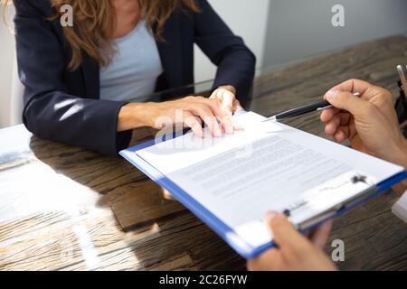 Close-up Of A Real Estate Agent Helping Client In Filling Contract Form Stock Photo