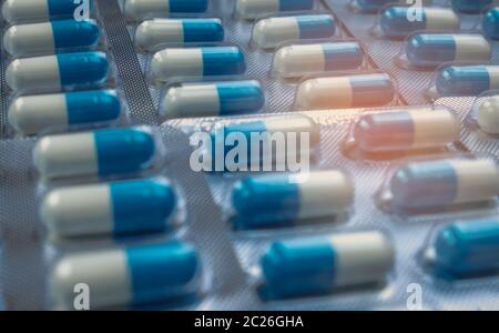 Blue and white capsules pill in blister pack arranged with beautiful pattern. Global healthcare concept. Antibiotics drug resistance. Antimicrobial ca Stock Photo