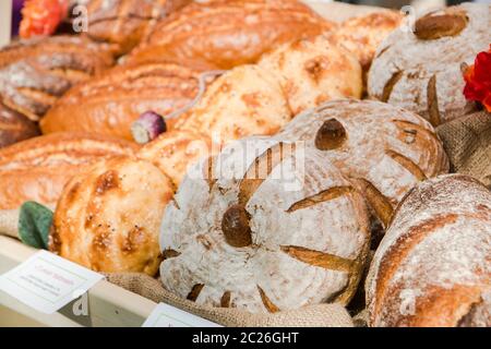 different fresh bread on the shelves in bakery Stock Photo