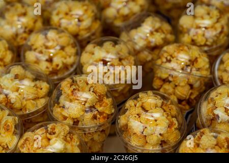 Popcorn in a plastic cup is beautifully placed. Unhealthy food or snack concept. Tasty salty popcorn. Carbohydrates food. Junk food. Popcorn on plasti Stock Photo