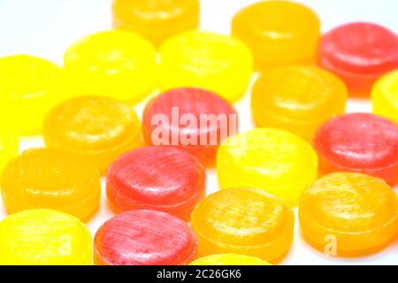 Medical lozenges for relief cough, sore throat and throat irritation isolated on white background. Cough and colds drop. Colorful cough pastille. Red, orange, and yellow round candy or sweets. Stock Photo