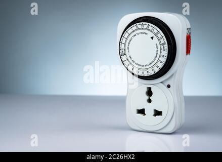 Plug-in timer mechanical 24 hour. Indoor home tools. Plug-in timer socket set isolated on white background. Mechanical outlet timer. Home security sup Stock Photo