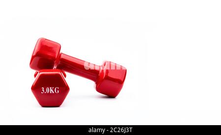 Two red dumbbells isolated on white background with copy space for text. 3.0 kg dumbbell. Weight training equipment. Bodybuilding workout accessories. Stock Photo