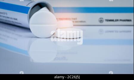 White effervescent tablets on blurred background of tube drug container. Pharmaceutical products. Pharmacy drug store background. Mucolytic medicine f Stock Photo