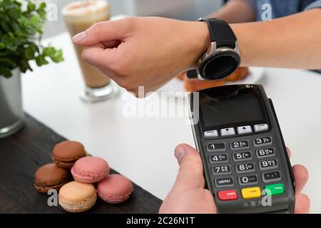 Customer making wireless or contactless payment using smartwatch, nfc payment Stock Photo