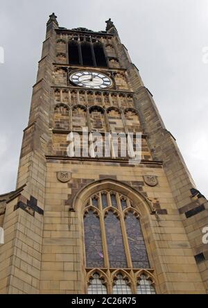 view of the clock tower and building of the historic saint peters parish church in the center of huddersfield against a cloudy s Stock Photo