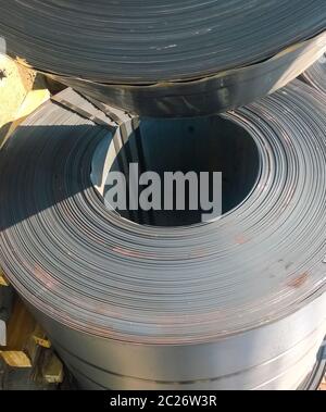 Steel sheets rolled up into rolls. Export Steel. Packing of steel for transportation. Stock Photo