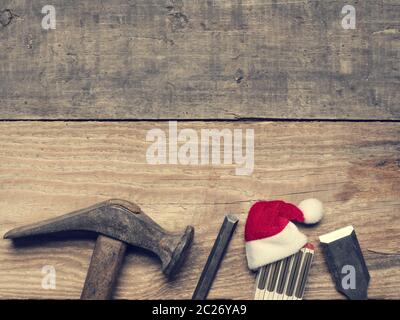 Old used carpenter tools with the hat of Santa, industrial Christmas background with space for text or image Stock Photo
