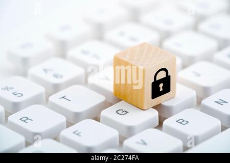 Wooden block with lock graphic on computer keyboard. Computer security concept. Stock Photo