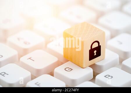 Wooden block with lock graphic on computer keyboard. Computer security concept. Stock Photo