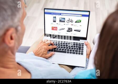 Couple Using Laptop For Shopping Online At Home Stock Photo