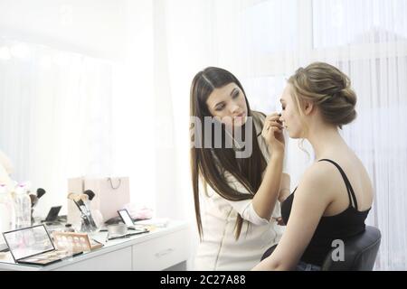 Professional make up artist doing make up in beauty salon Stock Photo