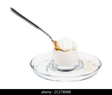 soft-boiled white egg with spoon in glass egg cup isolated on white background Stock Photo