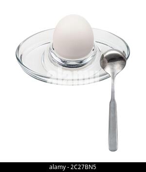 whole boiled white egg and spoon in glass egg cup isolated on white background Stock Photo