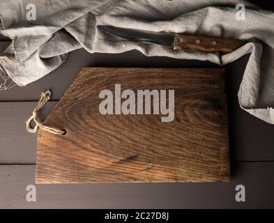empty old wooden kitchen chopping boards and a gray towel on a brown table, view from the top Stock Photo