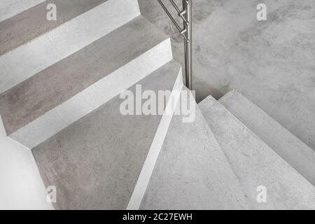 Grey microcement stairs. Stairs viewed from above. Modern design and innovative material. Metal railing. Stock Photo
