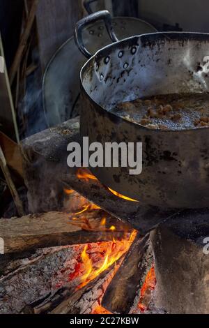 Old wood burning stove with big pan in a dirty kitchen Stock Photo