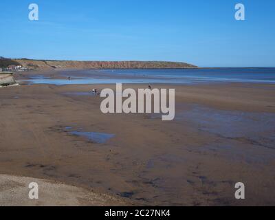 View over the sandy beach at Filey, North Yorkshire, England, towards Filey Brigg at low tide Stock Photo