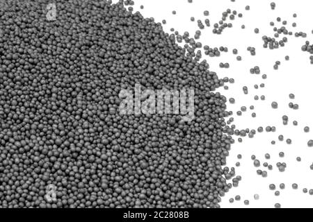 pile of dark polystyrene beadlets in white back Stock Photo
