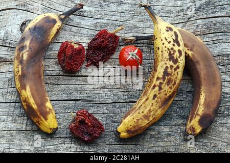 Old brown bananas and dried peppers and tomatoes. Old fruit and vegetables Stock Photo