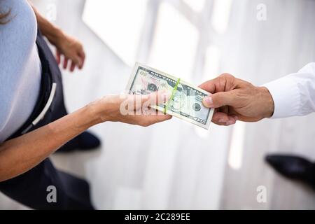 Close-up Of A Businessperson's Hand Taking Bribe From Partner Stock Photo