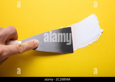 Close-up Of Painter's Hand Puttied Wall Using A Paint Trowel Stock Photo