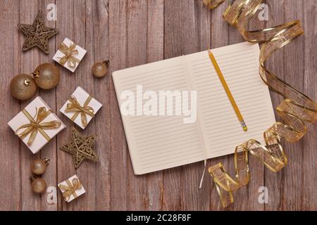 Wooden vintage background with blank sheets in diary, gift boxes and Christmas ornaments. Top view with copy space. New Year and Christmas,  For greet Stock Photo
