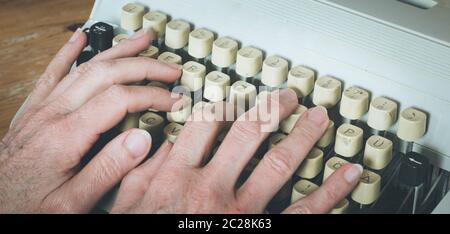 Man is typing on a vintage typewriter Stock Photo