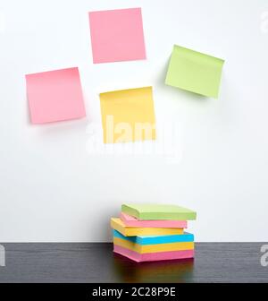 stack of multi-colored sticky stickers on a black wooden table, concept back to school Stock Photo