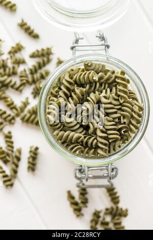 Uncooked colorful pasta with spinach flavor in jar. Top view. Stock Photo