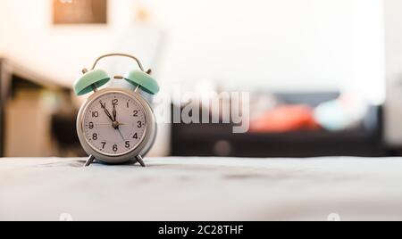 White alarm clock on the bed, morning, copyspace Stock Photo