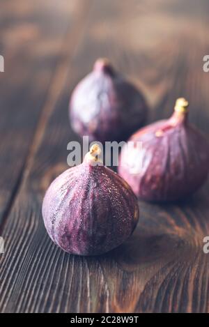 Three fresh figs on the wooden table Stock Photo