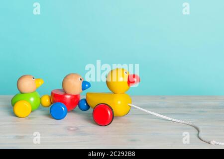 Wooden toy ducks a kids toy to pull around against a blue background with space for copy Stock Photo