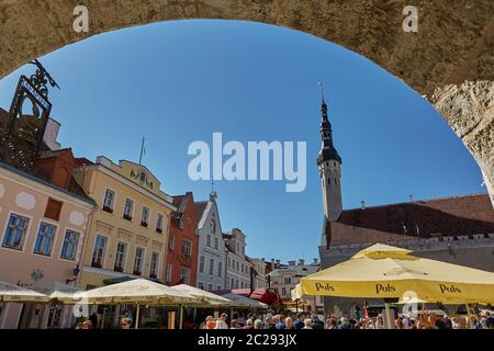 Tourists crowd enjoying shopping at the medieval Town Square in the walled city of Tallinn Estonia.