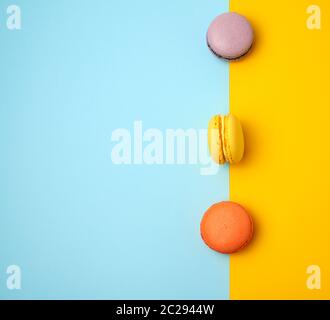 multi-colored baked round macarons on a colored background, flat lay Stock Photo
